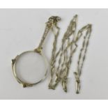 A pair of late Victorian white metal lorgnette, with button system, on a faceted link chain, the