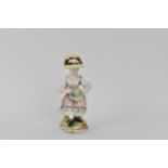 A 19th century Meissen figure modelled as a girl sat on a rock holding a basket of flowers, on a