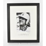 A signed reprinted photograph of Jack Brabham in a racing car, printed with the original negative,