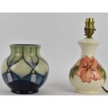 Moorcroft Pottery - a hibiscus pattern table lamp on a white ground, 18cm high, and a geometric