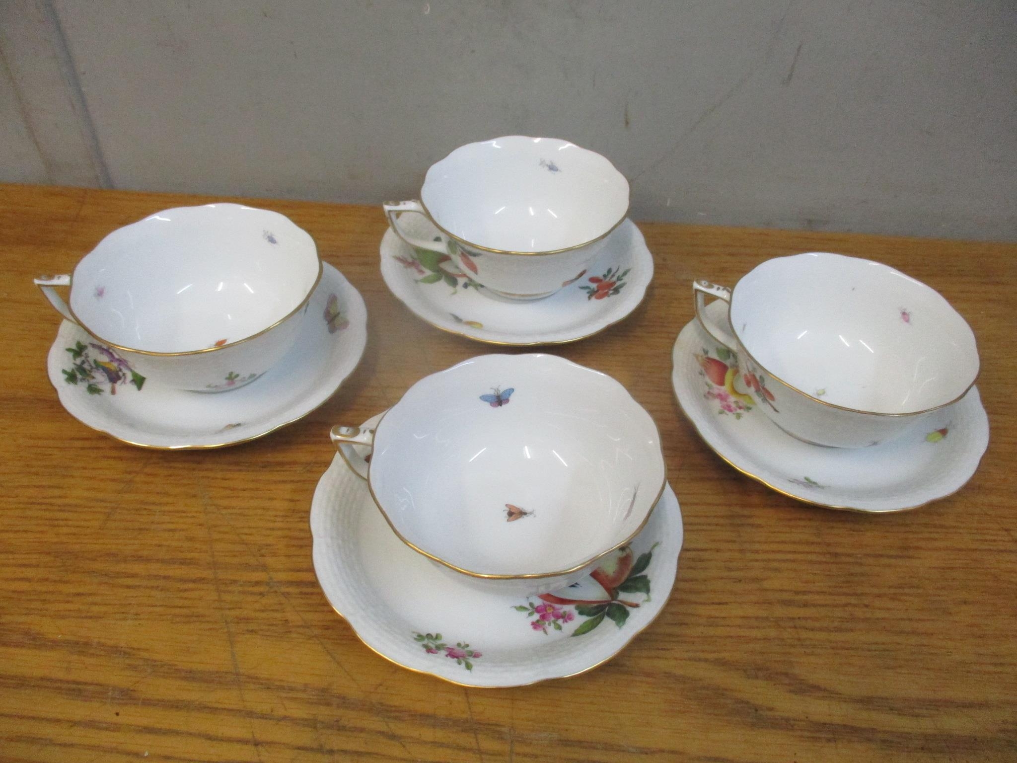 Four Herend cups and saucers each decorated with fruit and flowers with three of the cups are signed