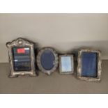 Four 20th century embossed silver photograph frames with easel backs, the largest 22cm h x 15cm w