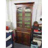 A Victorian mahogany bookcase having twin glazed doors above a cushion moulded drawer and two