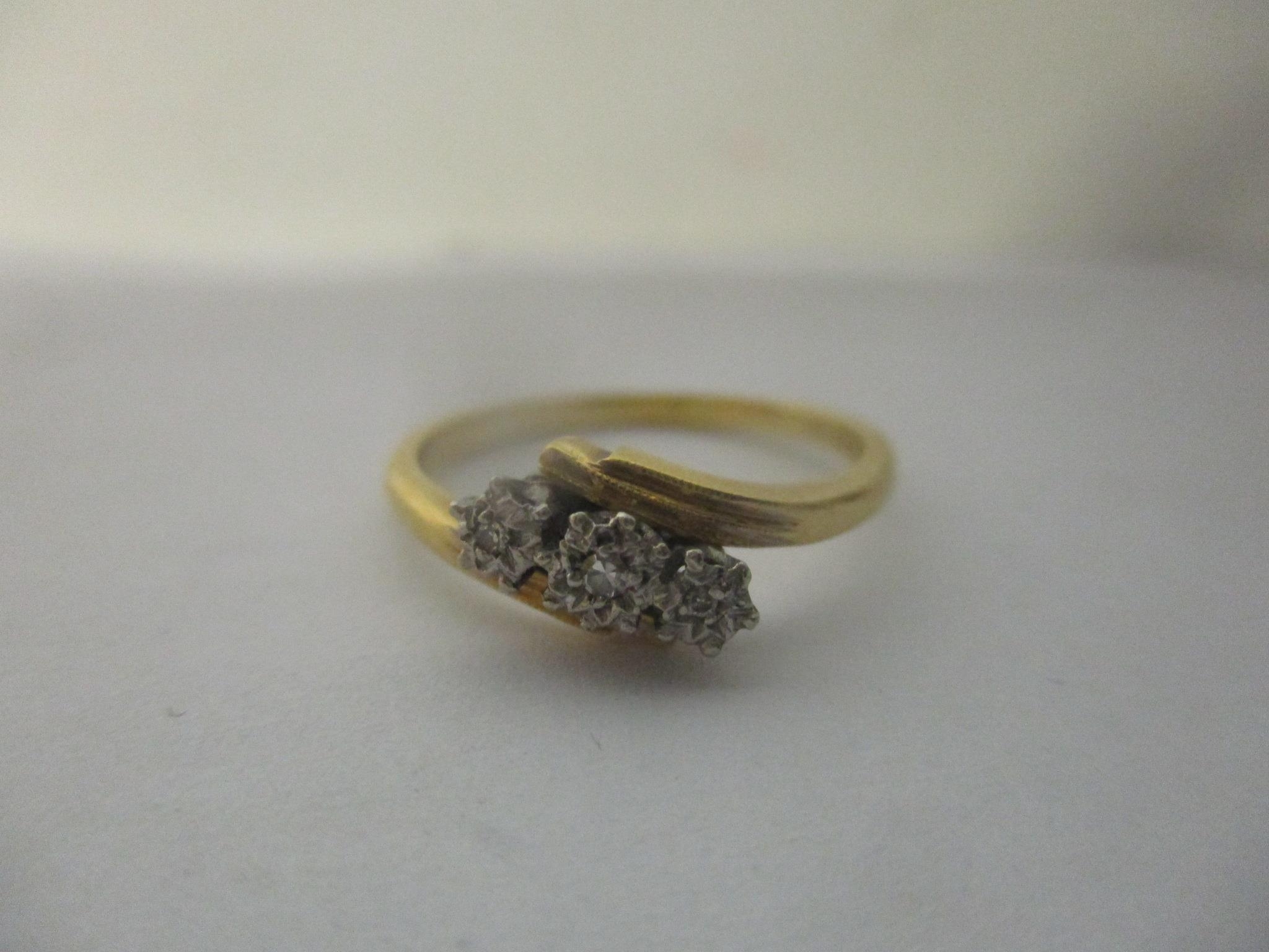 An 18ct gold and platinum ring inset with three illusion set diamonds Location: