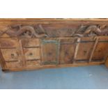 A 20th century and earlier North American sideboard having a carved front with six cupboard doors on