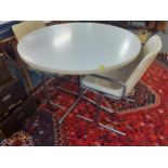 A retro white Formica top circular breakfast table with matched chairs having chrome supports.A1F