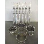 A selection of four silver napkin rings, 50.1g together with six silver handles forks Location: