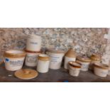 A quantity of early 20th century stoneware grocery and other establishment advertising jars and