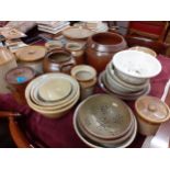 A quantity of early 20th century kitchen stoneware storage jars, sieves and bowls Location: G