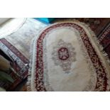 Four rugs to include a Persian pink silk ground rug and two John Lewis Chinese rugs, one circular