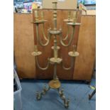 A Middle Eastern brass nine branch candelabrum having engraved decoration and scroll shaped feet,