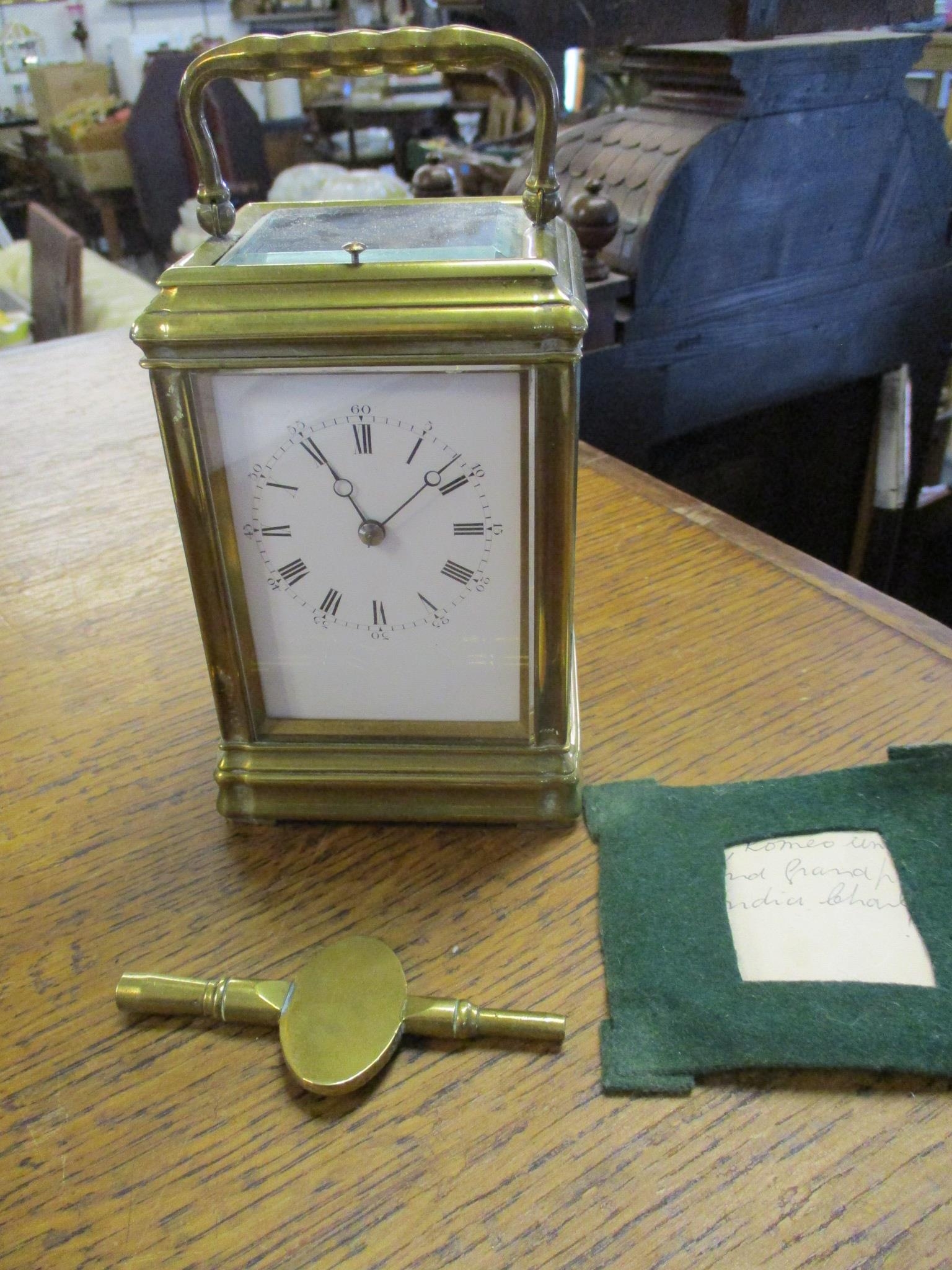 An early 20th century brass cased fire window, repeating carriage clock, with moon hands, white