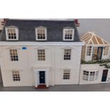 A cream painted Georgian style house on 3 floors with additional garage and conservatory, with