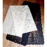 A Victorian Nottingham black lace shawl decorated with a border of large flowers and leaves