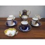 A Sevres porcelain teapot and three coffee cans and saucers decorated with cherubs holding a