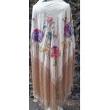An early 20th Century cream ground crinoline shawl with embroidered flowers in pink, purple and