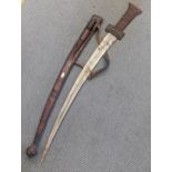 An African tribal sword having a 77cm curved blade engraved to both sides together with leather