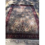 A Egyptian rug hand woven in an Islamic floral design on a cream ground, with single wide guard