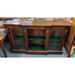 A late Victorian walnut breakfront bookcase having inlaid decoration, applied brass mounts and on