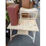 A Lloyd Loom style, white painted two tier table with matching stool, a pink painted laundry