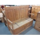 An 18th century pine settle having a panelled back and hinged seat, 127cm h x 142cm w Location:
