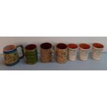 A group of glazed pottery mugs to include 3 commemorative mugs, 1952 and 1977, a Palestine mug,