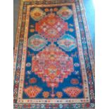 A Turkish rug having a navy blue ground with red, orange, blue and lilac geometric pattern, 186cm