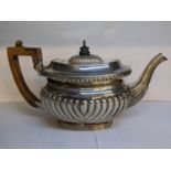 An early 20th century silver teapot having gadrooned and reeded decoration, 423.7g Location: