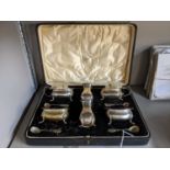 An early 20th century cased set of silver condiments to include, salt, pepper, mustard and others