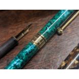 A collection of mixed pens to include a L'Plume example, mixed Parker pens and others in a burr yule