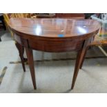 An early 19th century mahogany fold over card table having a green baize and on tapered legs