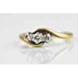 An 18ct yellow gold three stone diamond ring with three graduated stones, the central brilliant