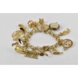 A 14ct yellow gold charm bracelet, the three-ring cable chain holding sixteen charms of various