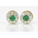A pair of 18ct yellow and white gold, emerald and diamond cluster earrings, each set with central