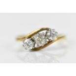 An 18ct yellow gold and platinum diamond three stone crossover ring, set with a central old European