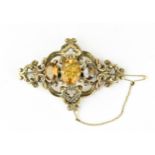 A Victorian yellow metal and citrine brooch, with central oval cut stone flanked with two smaller