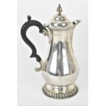 An Edwardian silver coffee pot by Charles Stuart Harris, London 1904, of baluster form with domed