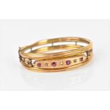 A Gypsy style yellow metal, ruby and diamond bangle bracelet, with starburst set old cut diamonds