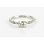A platinum solitaire diamond ring, approximately 0.6ct diamond and eighteen diamonds to the