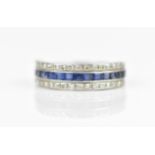 A white metal, diamond and sapphire half eternity ring, with a central row of sixteen step cut