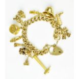 A 9ct yellow gold curb link charm bracelet, with eleven assorted charms to include dice, a crown,