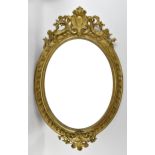 A large 19th century carved and giltwood oval mirror, with pierced acanthus and floral crest, beaded