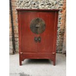 A large Chinese red lacquer wedding cabinet, with moon lock to the central doors enclosing two