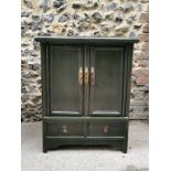 A 20th century Chinese green lacquer cabinet, of rectangular form with twin doors enclosing one