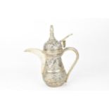 A Middle-Eastern white metal Dallah coffee pot, designed with embossed foliate friezes throughout,