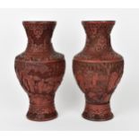 A pair of Chinese red cinnabar lacquer vases, of baluster shape with carved continuous scene of