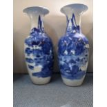 A pair of large Japanese early 20th century blue and white vases each decorated with a continuous