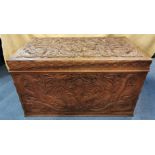 An early 20th century Chinese camphor chest, with carved dragon design to the lid and sides, the