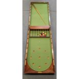 A late 19th century mahogany folding bar billiards game with balls and cue