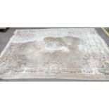 A Chinese machine woven cream ground carpet having a floral design with a central motif, 370cm x